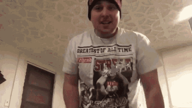 a man wearing a shirt that says greatest of all time on it