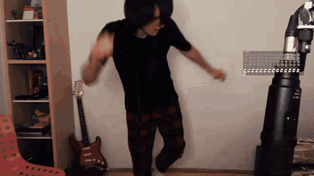 a man is dancing in front of a guitar and a keyboard