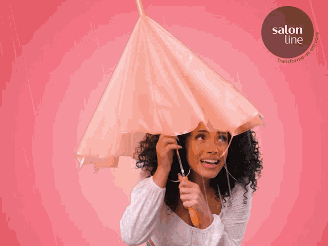a woman with curly hair is holding an umbrella in front of a pink background that says salon line