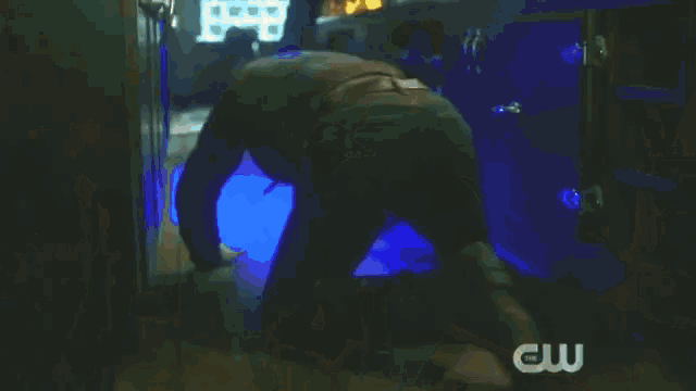 a man is jumping over a bar with a cw logo on the bottom of the bar