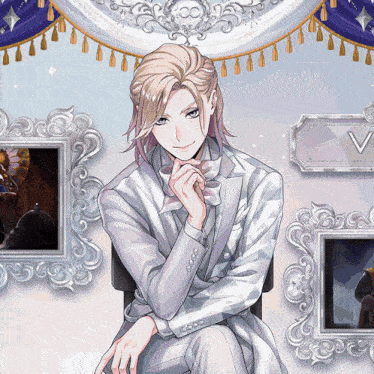 a man in a white suit sits in front of a sign that says " v "