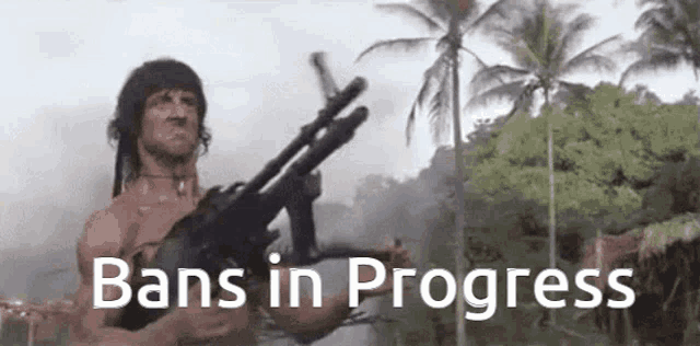 a man is holding a gun in front of a forest with the words `` bans in progress '' written below him .