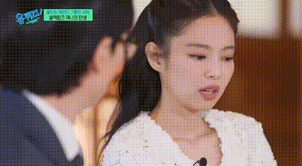 a woman in a white dress is talking to a man in a suit on a tv show .