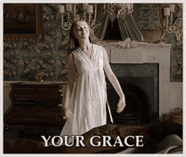 a woman in a white dress is dancing in front of a fireplace with the words " your grace " written below her