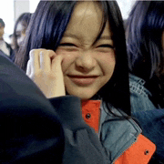 a girl with long black hair is smiling and making a face