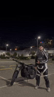 a man in a black jacket is riding a motorcycle at night