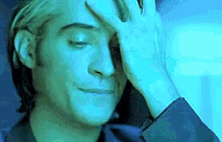 a man is covering his face with his hand in a blue background .