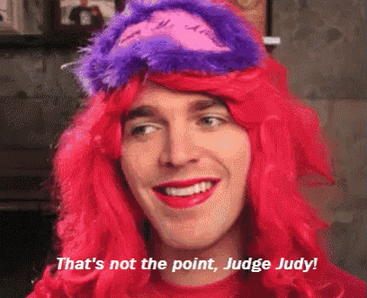 a man wearing a red wig and purple hat says that 's not the point judge judy !
