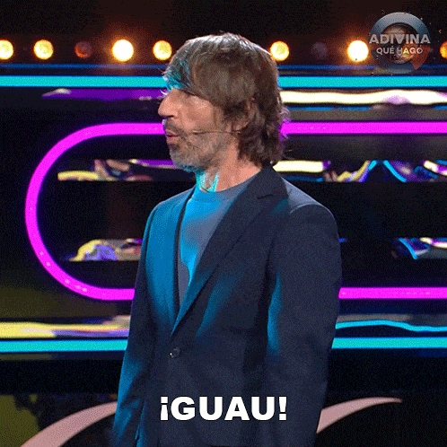 a man in a suit stands in front of a stage and says iguau