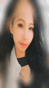 a woman with long black hair is wearing a white shirt and a black choker