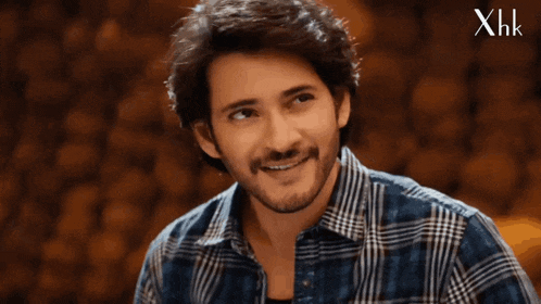 a man wearing a plaid shirt is smiling with xhk written on the bottom