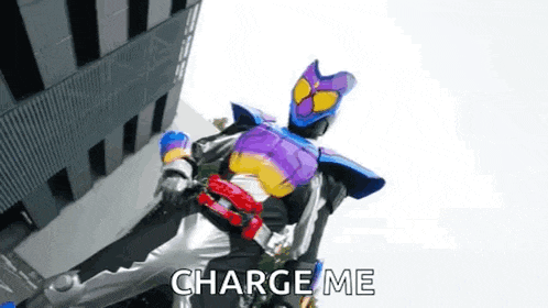 a kamen rider is standing in front of a building with the words `` charge me '' written on it .