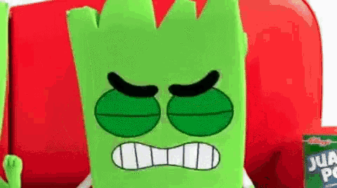 a green cartoon character with an angry face is sitting on a red chair next to a bottle of juice .