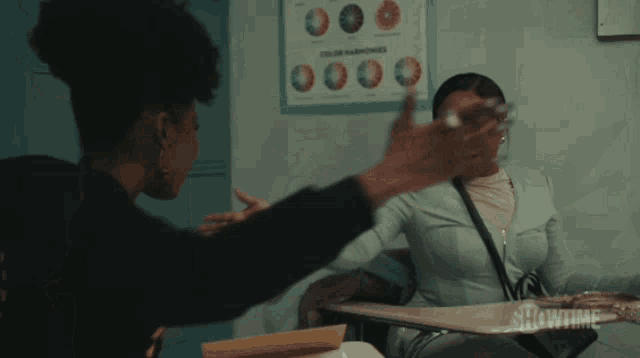 a showtime poster hangs on a wall above a girl 's desk