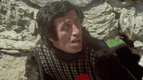 a man in a black and white sweater has a red heart on his shirt