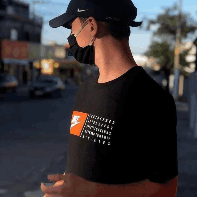 a man wearing a black nike shirt and a black hat