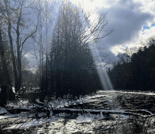 the sun is shining through the clouds over a river