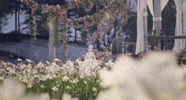 a doll in a white dress is standing in a field of flowers