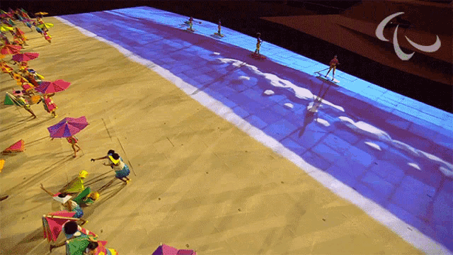 an aerial view of people on a beach with a paralympic logo
