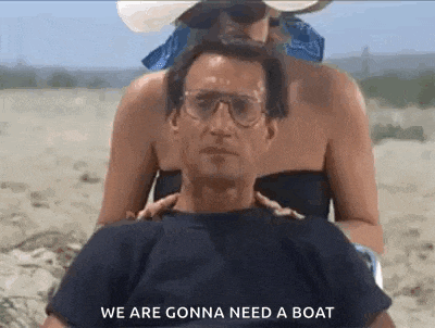 a man is sitting on a beach with a woman behind him .