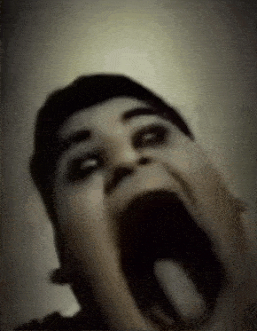 a close up of a person making a funny face with their mouth open