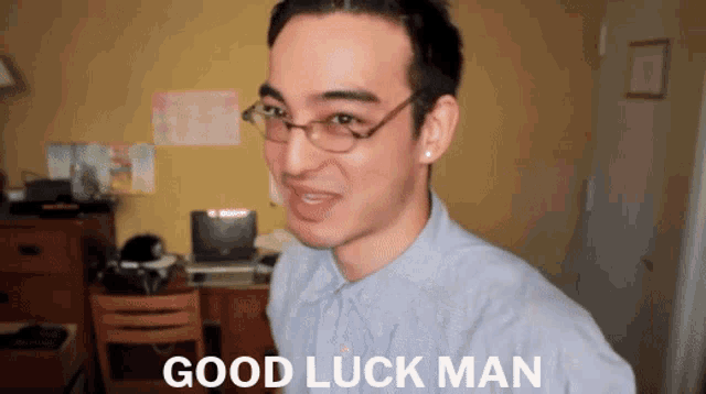 a man wearing glasses and a blue shirt says good luck man