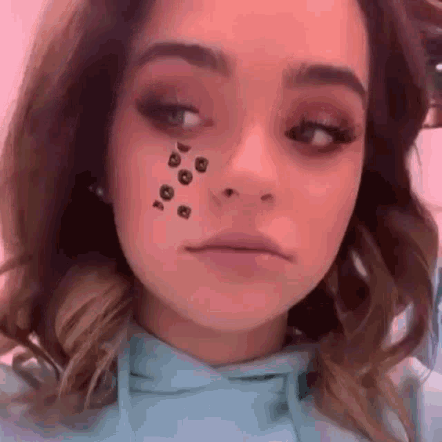 a close up of a woman wearing a blue hoodie with a leopard print on her face .
