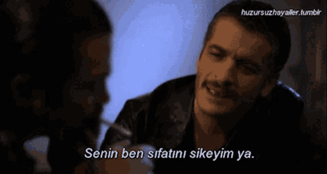 a man with a mustache is smoking a cigarette and says " senin ben sifatini sikeyim ya "