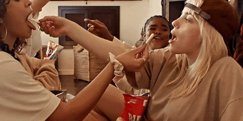 a woman is eating chips from a bag that says ritz