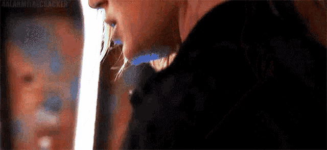 a man is drinking from a bottle of beer in front of a mirror .