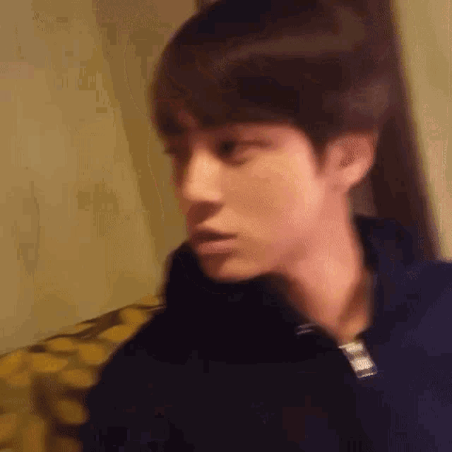 a blurry picture of a man sitting on a couch .