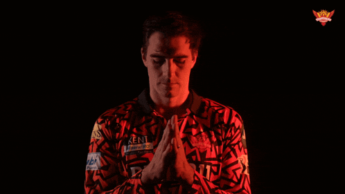 a man wearing a kent shirt with his hands folded