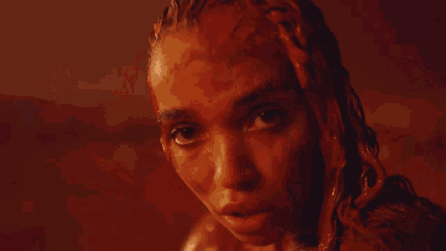 a close up of a woman 's face with red paint on her face