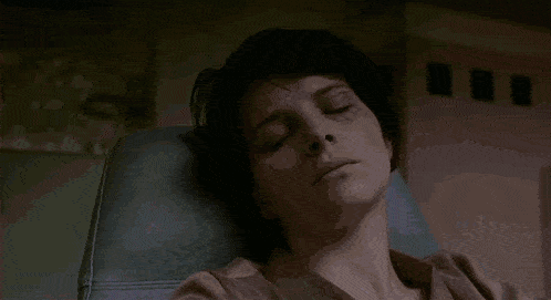 a woman is sitting in a chair with her head resting on her arm .