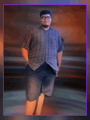 a man wearing shorts and a polka dot shirt is standing with his hands in his pockets