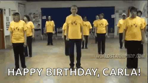 a group of people in yellow shirts are dancing in a room with the words `` happy birthday , carla ! ''