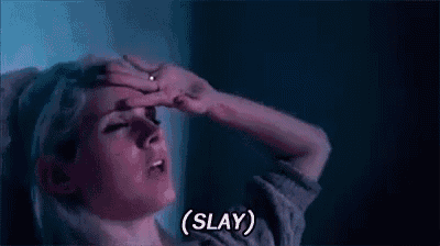 a woman is holding her hand to her forehead and says slay .