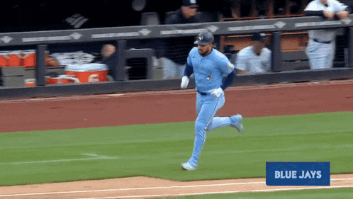 a blue jays player is running on the baseball field