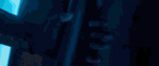 a close up of a person in a superhero costume with glowing eyes in the dark .