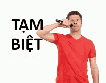 a man in a red shirt is brushing his teeth with a bottle of water .