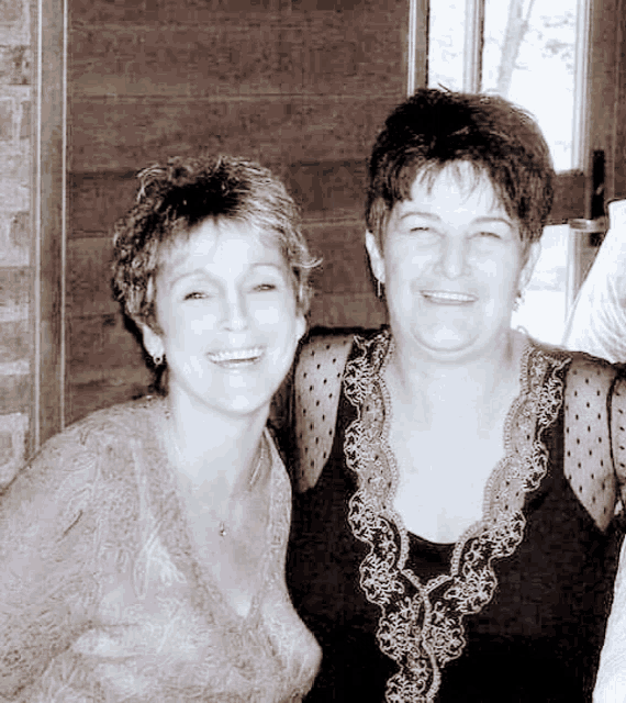two women are posing for a picture together and smiling for the camera
