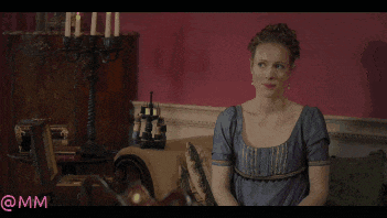 a woman in a blue dress sits on a couch