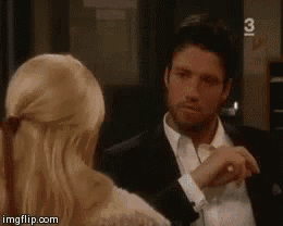a man in a suit and tie is talking to a woman in a white dress .