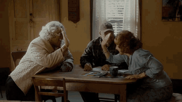a man and two women are sitting at a table