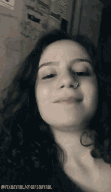 a woman with a nose ring is smiling in a black and white photo