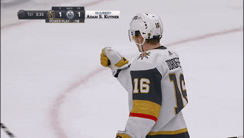 a hockey player with the number 16 on his jersey stands on the ice