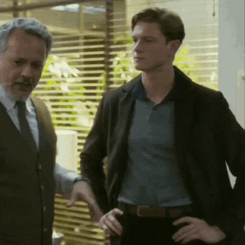 two men are standing next to each other with their hands on their hips