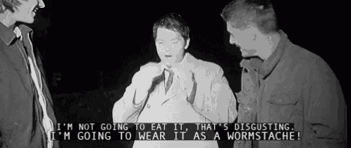a man in a trench coat is talking to two other men in a black and white photo