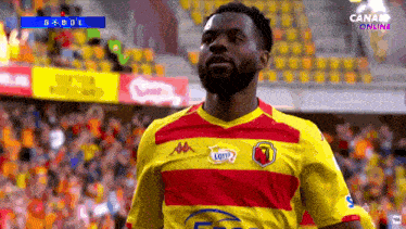 a soccer player wearing a yellow and red jersey that says lotto on it