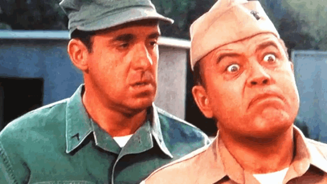 two men in military uniforms are looking at each other